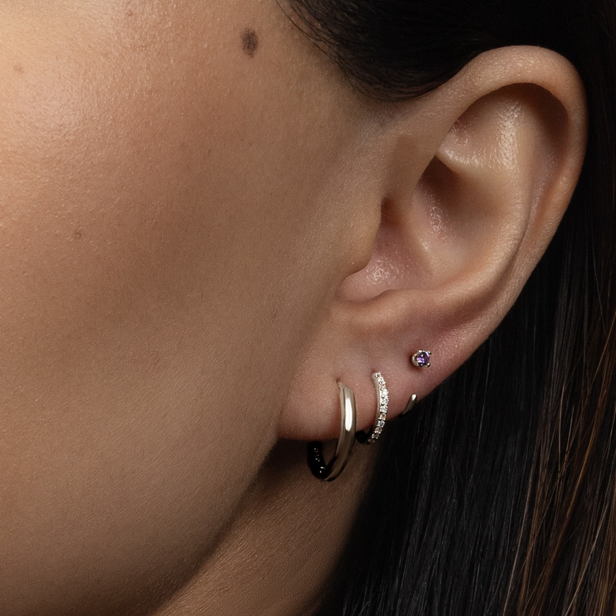 Close-up of an ear wearing Stay Close Amethyst Hoop with a blurred background